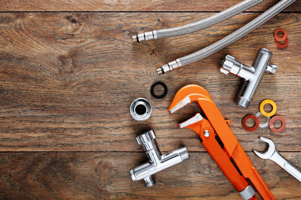 Set of plumbing tools on wooden table background. Close up top down view with copy space.